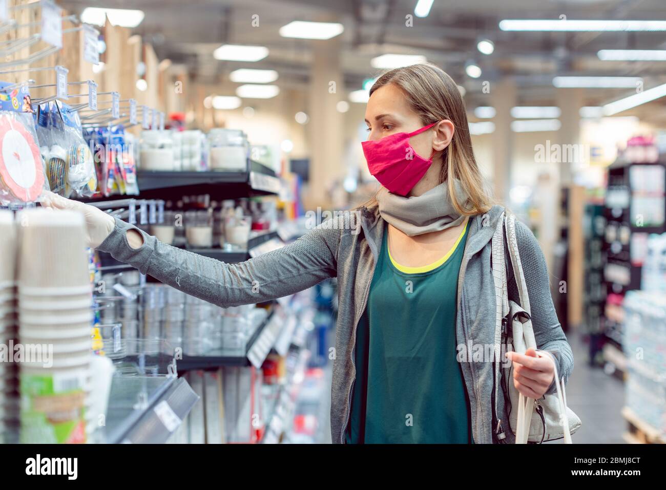 Woman with face mask in supermarket Stock Photo
