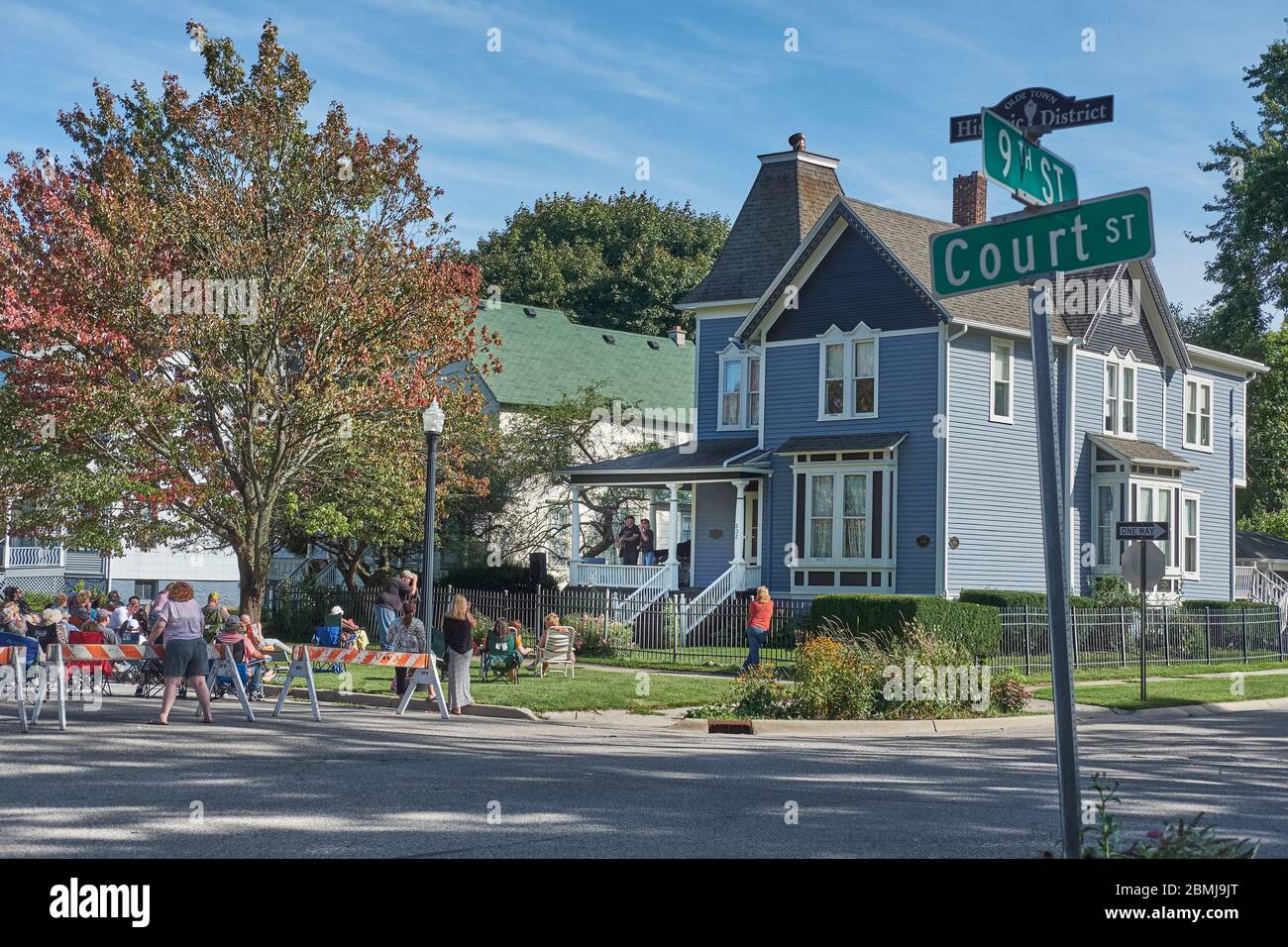 Crowd outside older house in historic district gathers to watch musicians perform at a free porch concert in small town Port Huron, MI USA. Stock Photo