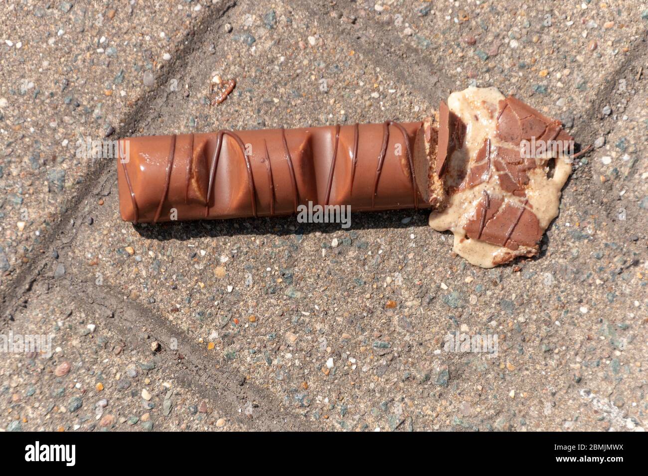 a close up view of a bar of chocolate that has been dropped and squashed on the one side Stock Photo