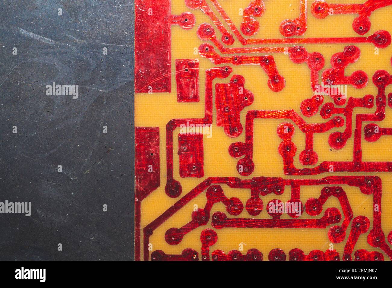 Handmade circuit board with red soldered tracks. industrial background. textolite with soldering Stock Photo