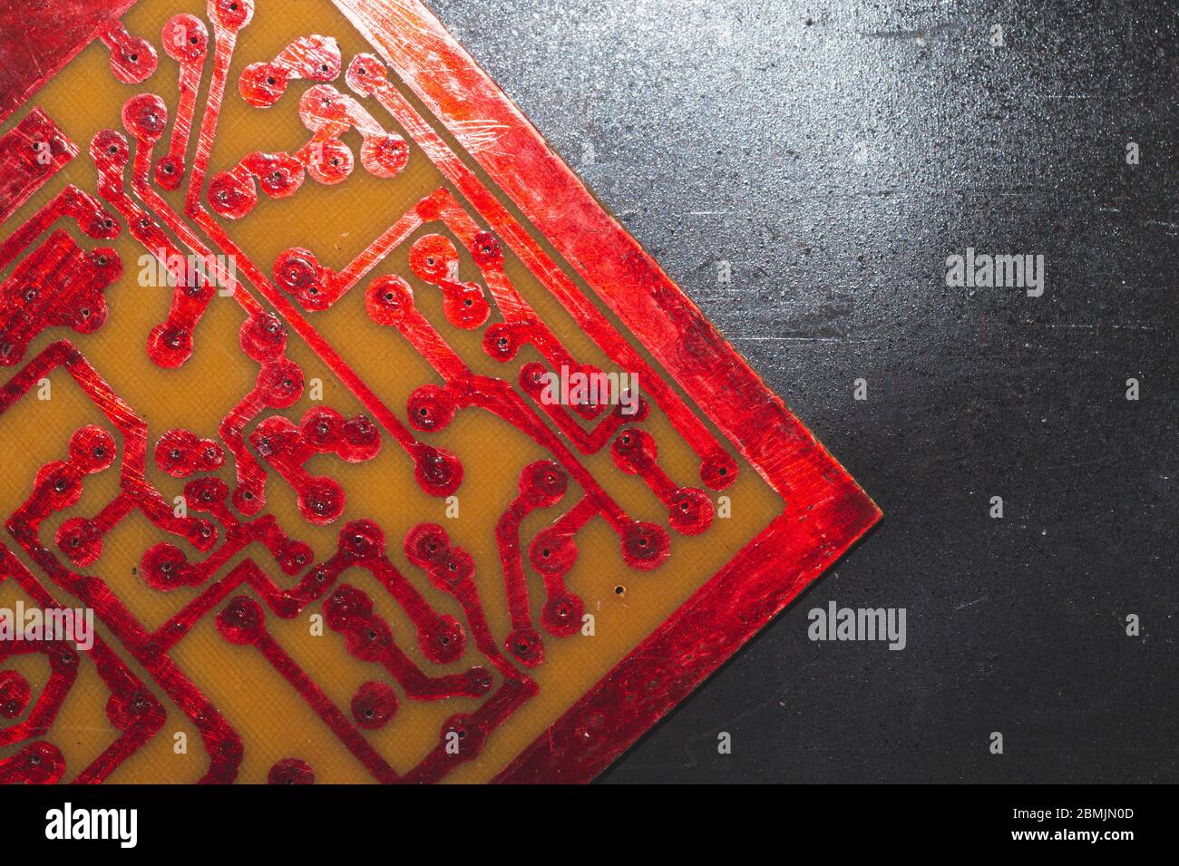 Handmade circuit board with red soldered tracks. industrial background. textolite with soldering Stock Photo