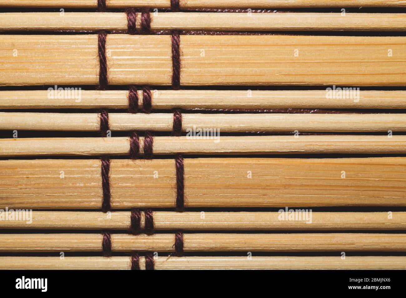 Bamboo mat background close up. wooden backdrop. wooden sticks bound together Stock Photo