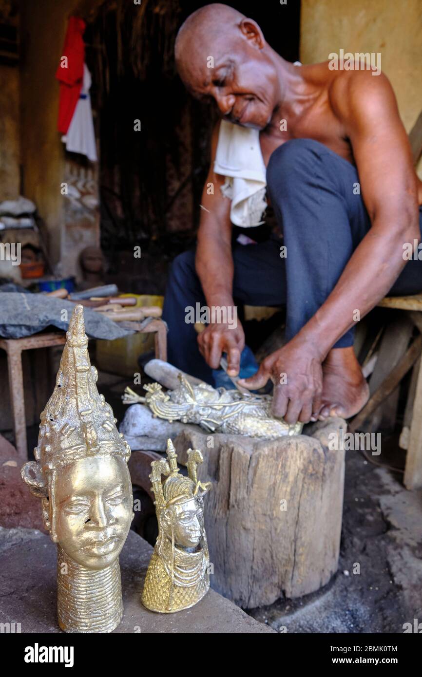 Craftsman finishing polishing the last details of a bronze statuette made using the technique of lost wax casting, used in the kingdom of Benin before Stock Photo