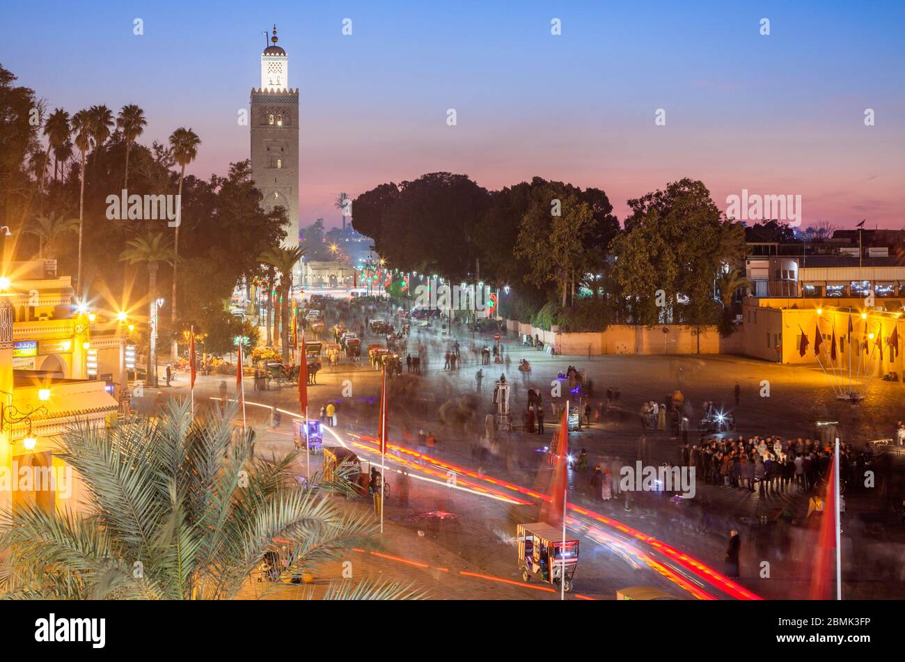 The Minaret of the Kasbah Mosque in the busy Jemaa el-Fnaa at sunset from a patio in Marrakesh, Marrakesh-Safi Morocco. Stock Photo