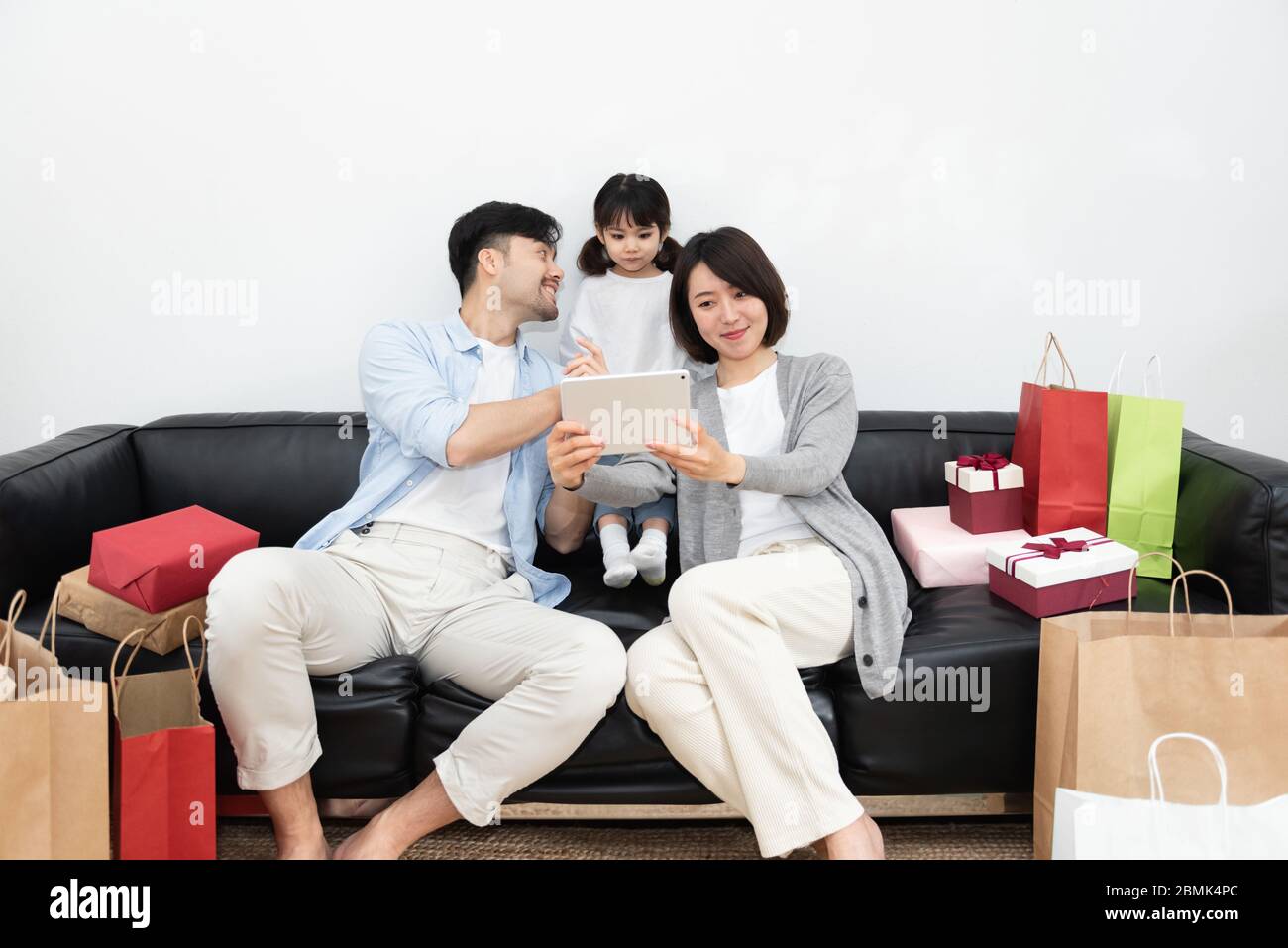 Young Asian mom and dad are unpacking gifts with their daughter Stock Photo  - Alamy