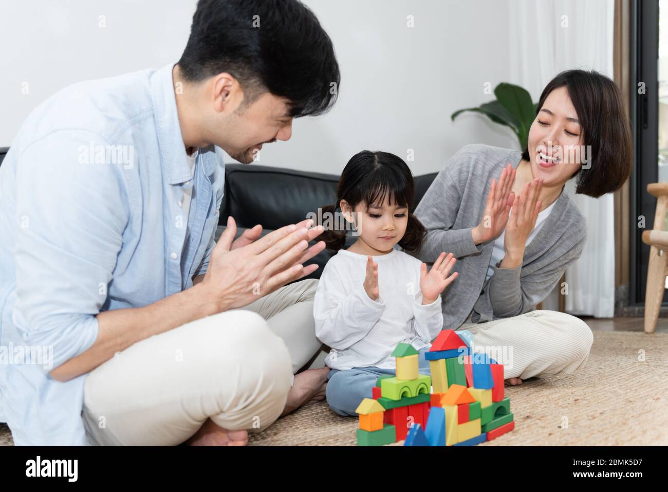 Young Asian mom and dad are building blocks with their daughter Stock ...