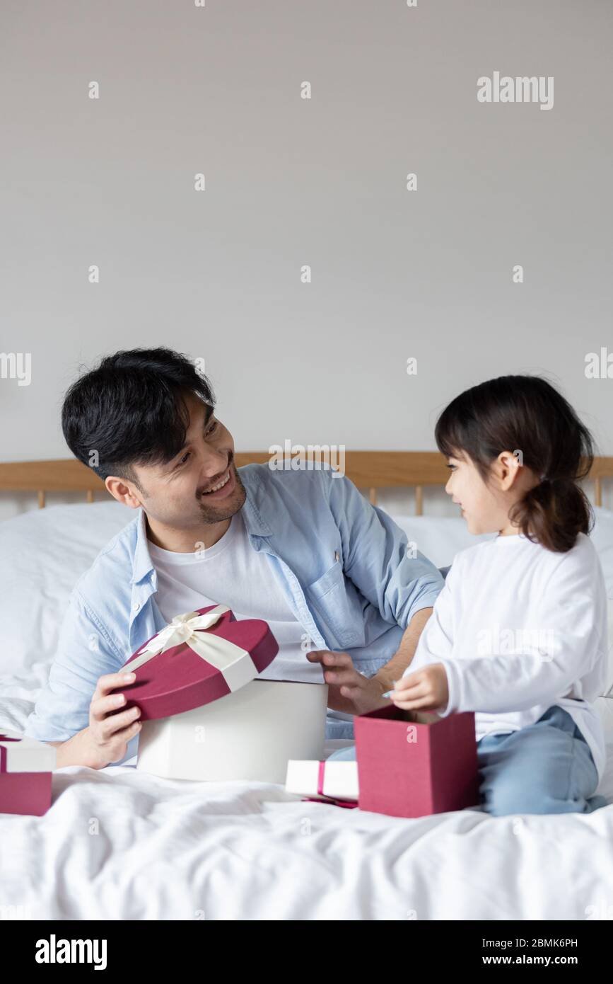 Young Asian mom and dad are unpacking gifts with their daughter Stock Photo  - Alamy