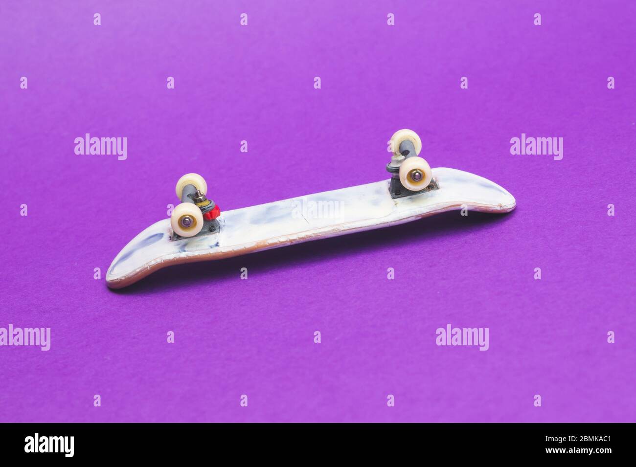 Small skateboard on purple background. tiny skate for fingers