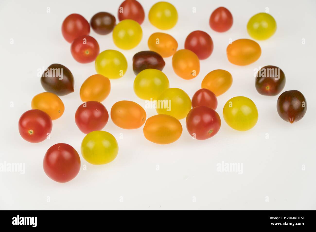 fresh multi-colored cherry tomatoes on a white background Stock Photo