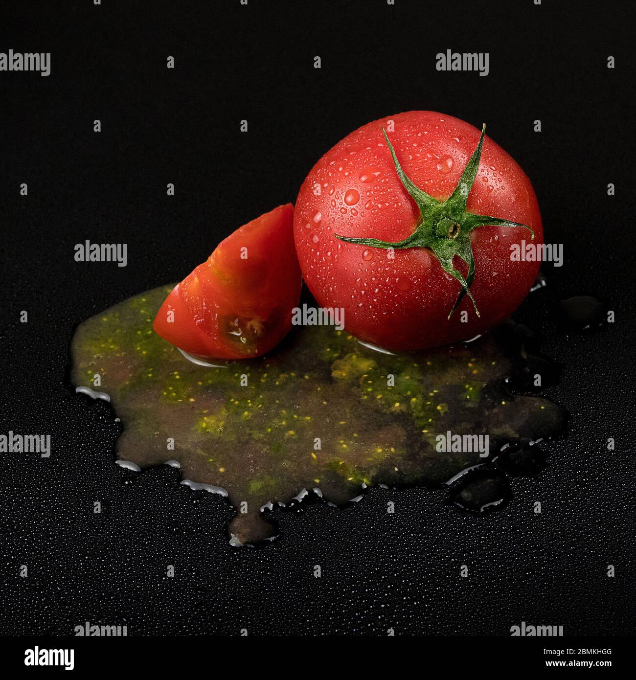 fresh wet tomatoes on a black background. sliced tomatoes with pulp