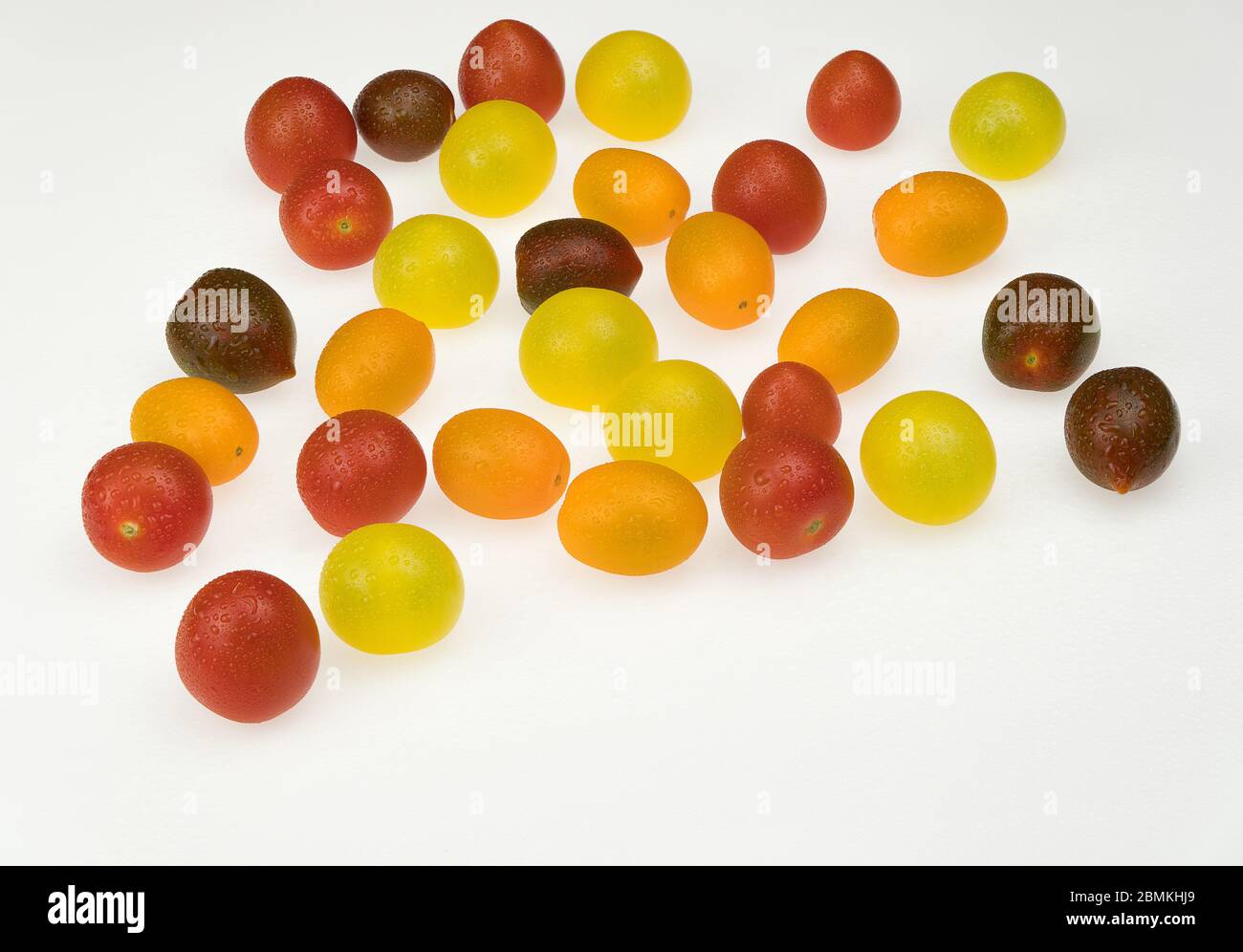 fresh multi-colored cherry tomatoes on a white background. wet tomatoes Stock Photo
