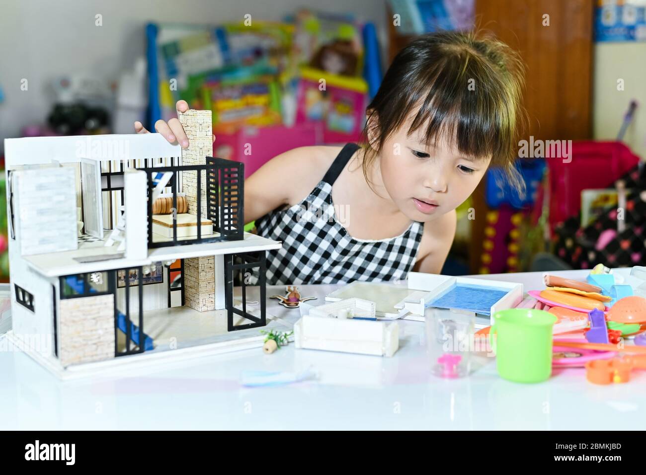 Asian little girl children playing at toy and leaning to enjoy the saturday morning at toy corner home building Stock Photo