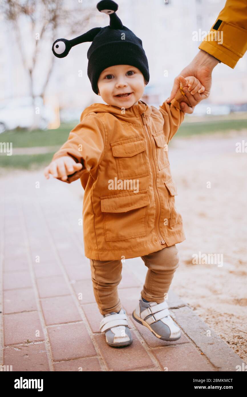 a child in a hat a snail with eyes on the street background Stock Photo