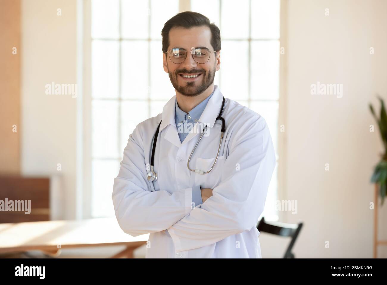 Portrait of smiling male Caucasian doctor posing at workplace Stock ...