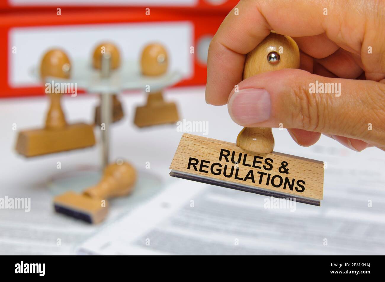 rules and regulations printed on rubber stamp in hand Stock Photo