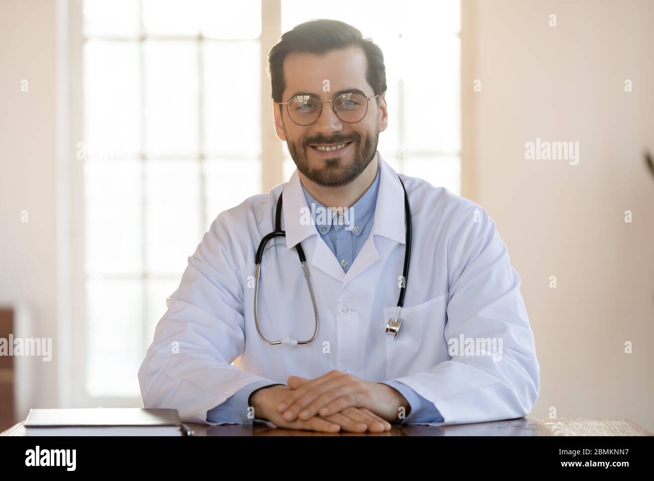 Portrait of smiling Caucasian male doctor at workplace Stock Photo - Alamy