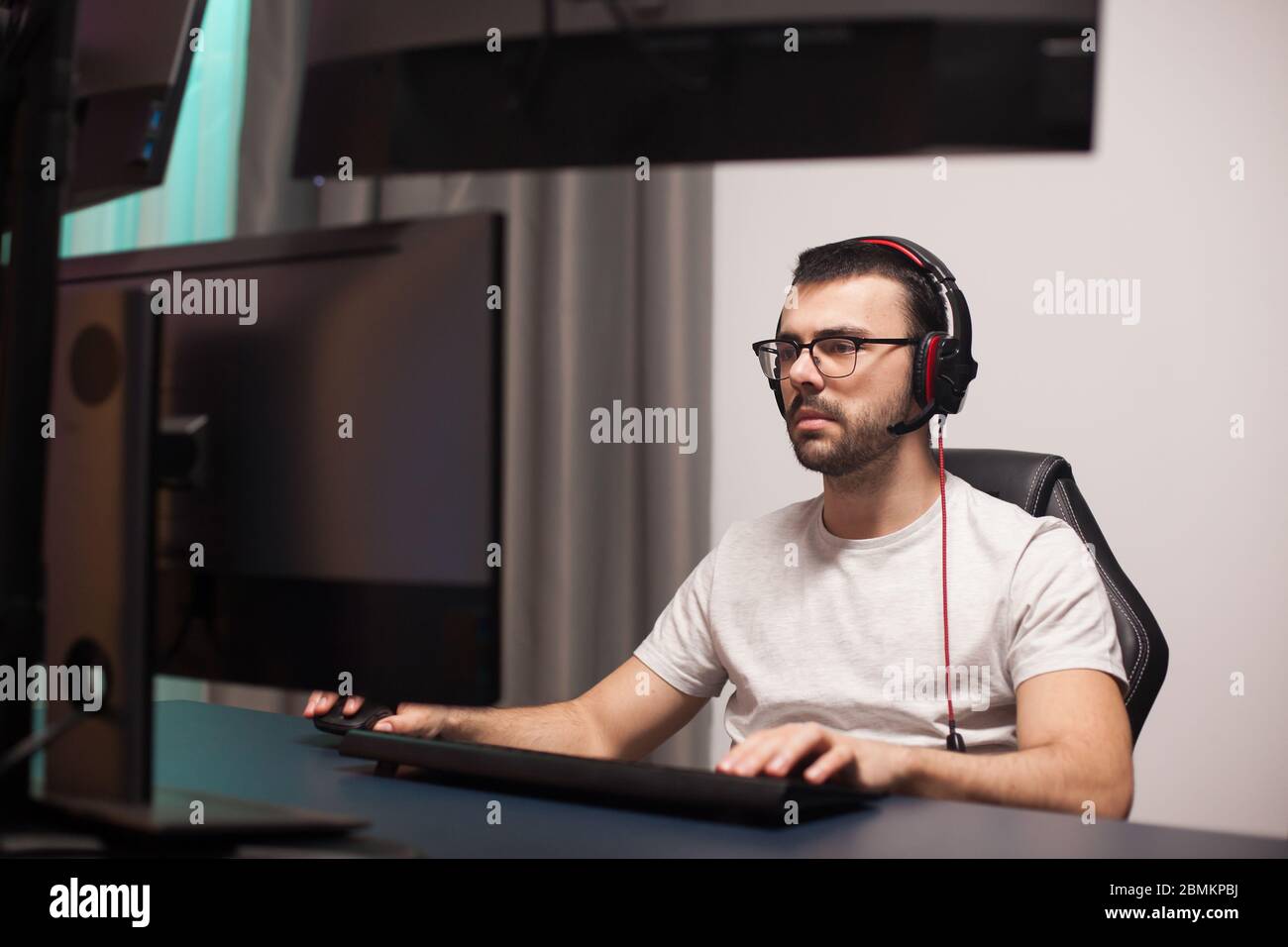 Portrait of professional gamer playing shooter games on powerful ...