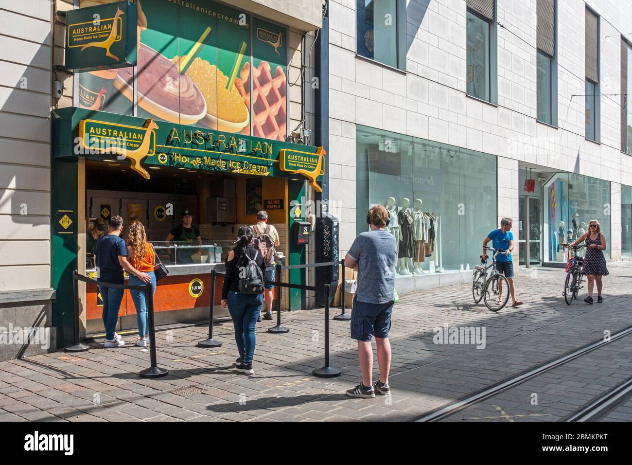Customers waiting outside in line in front of ice cream shop during 2020 COVID-19 / coronavirus / corona virus pandemic in Flemish city Ghent, Belgium Stock Photo
