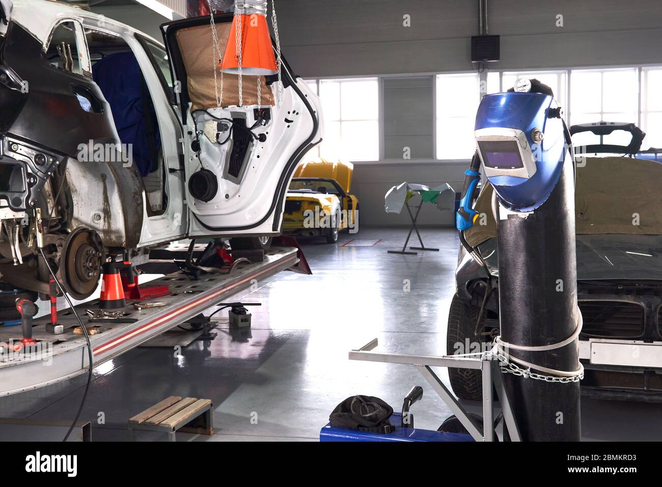 Welding equipment in a car repair station, helmet hanging on a gas tank, no people Stock Photo