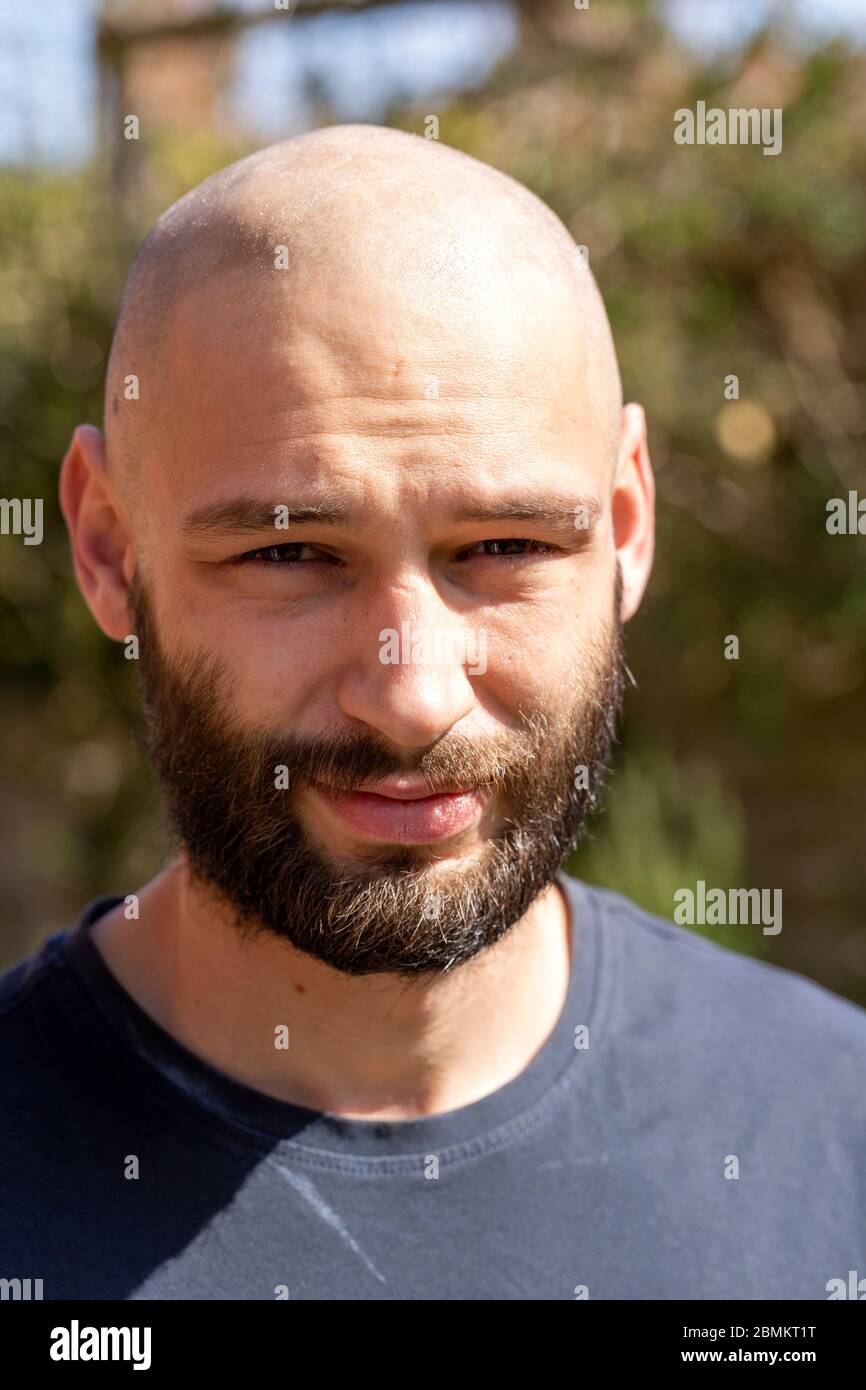 Full face portrait close up Caucasian white young man shaven head and
