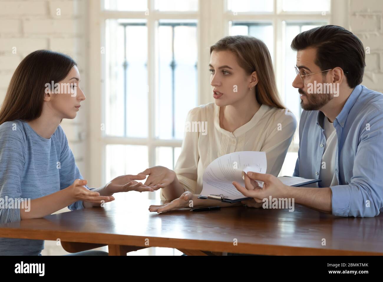 Angry couple argue with realtor about contract rules Stock Photo