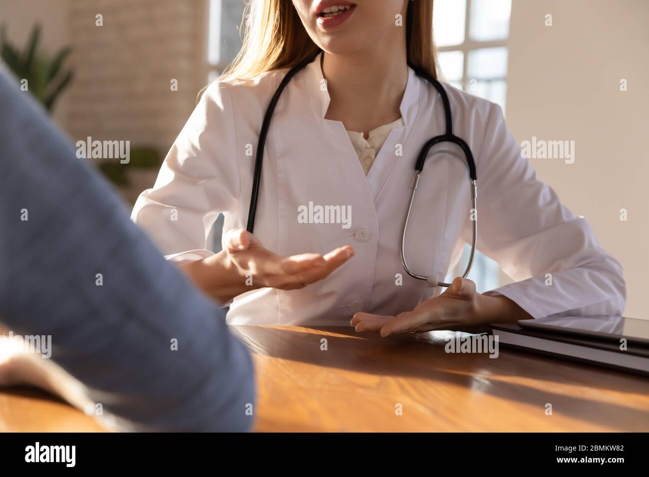 Caucasian female doctor consult patient at meeting Stock Photo