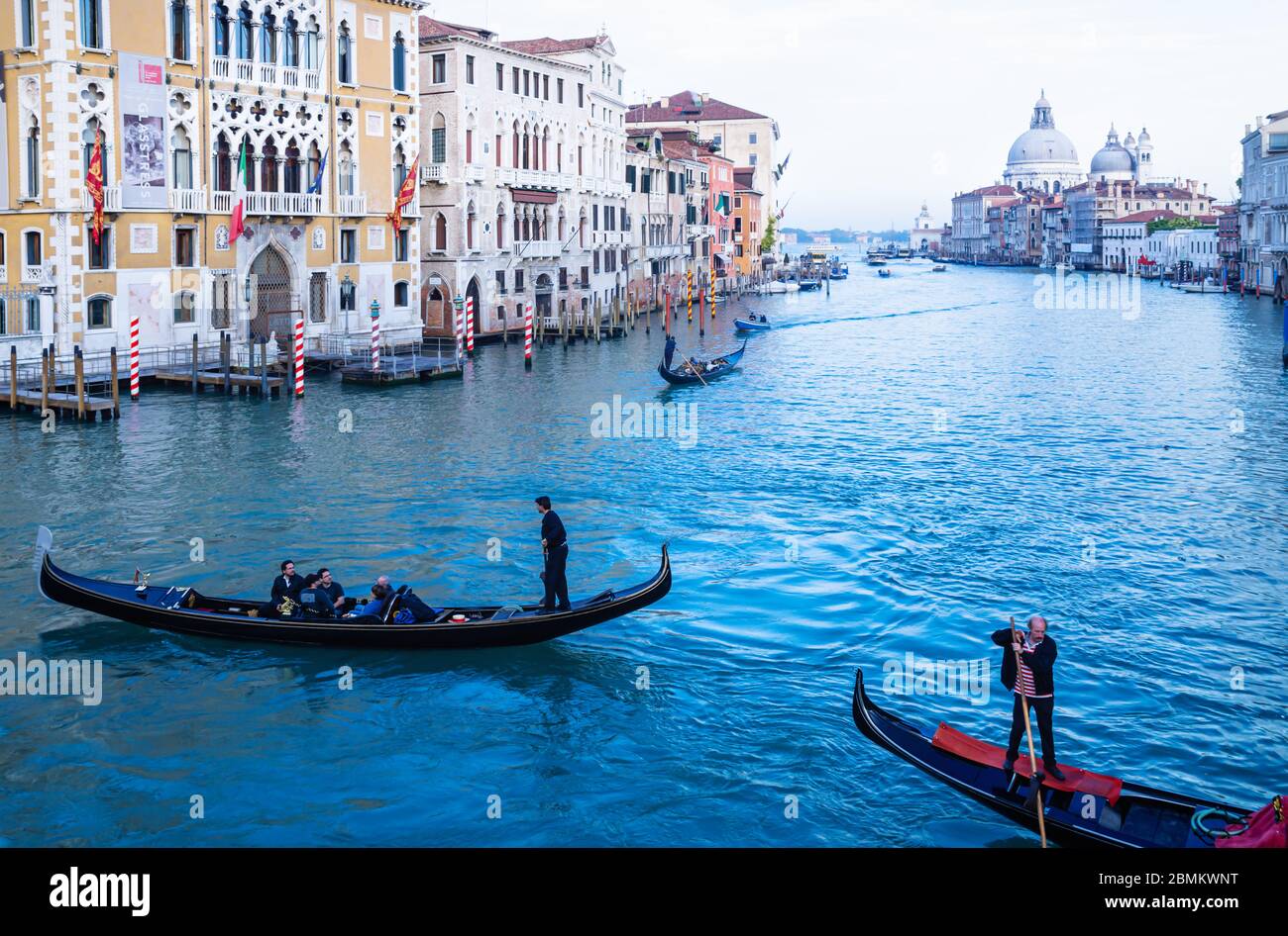 Tourists on Gondolas in the blue colored lagoon of Venice, Italy Stock ...