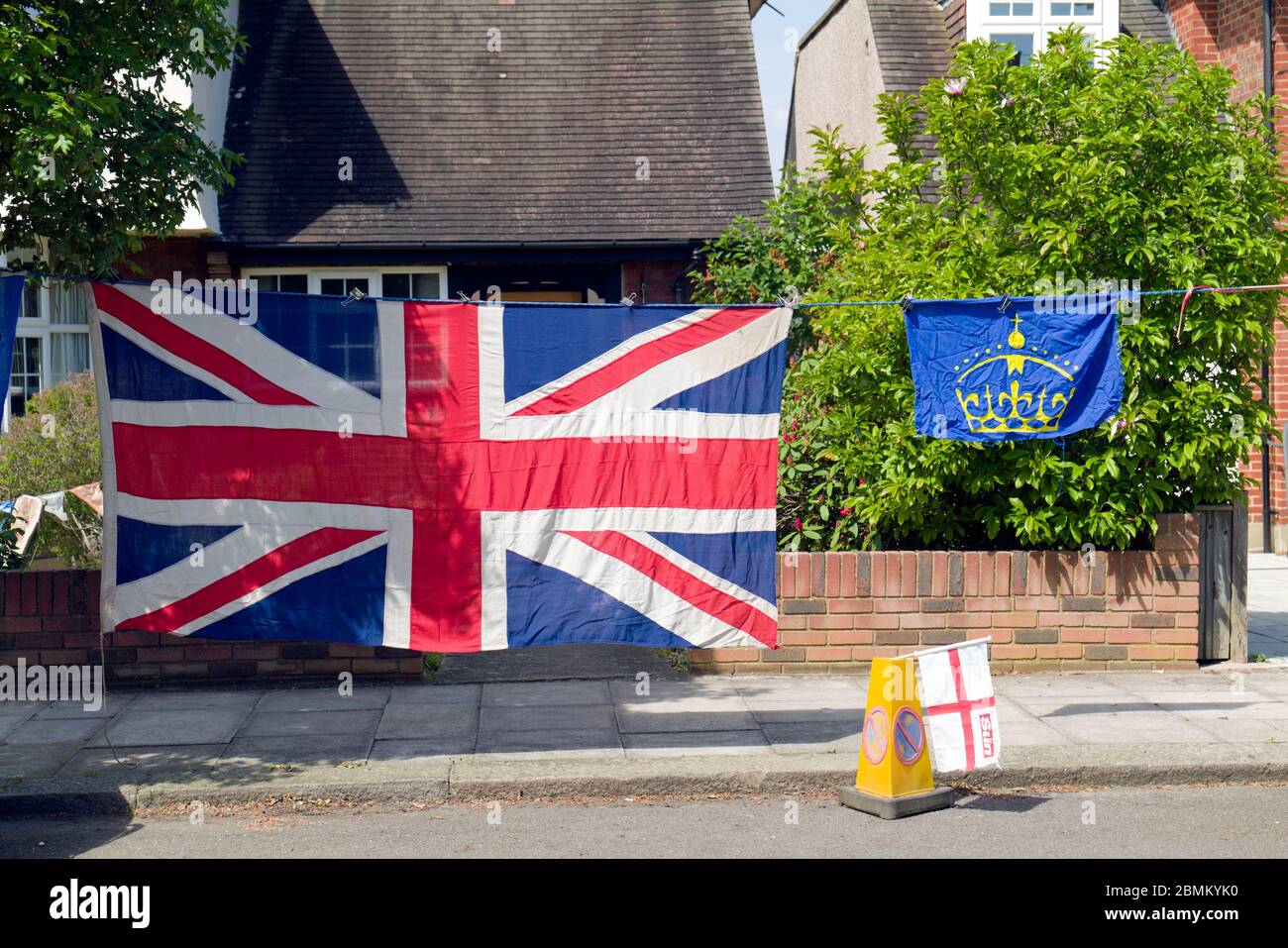 A large Union Jack Flag hanging outside a front garden in South West London celebrating the 75th Victory anniversary of victory in Europe. Stock Photo