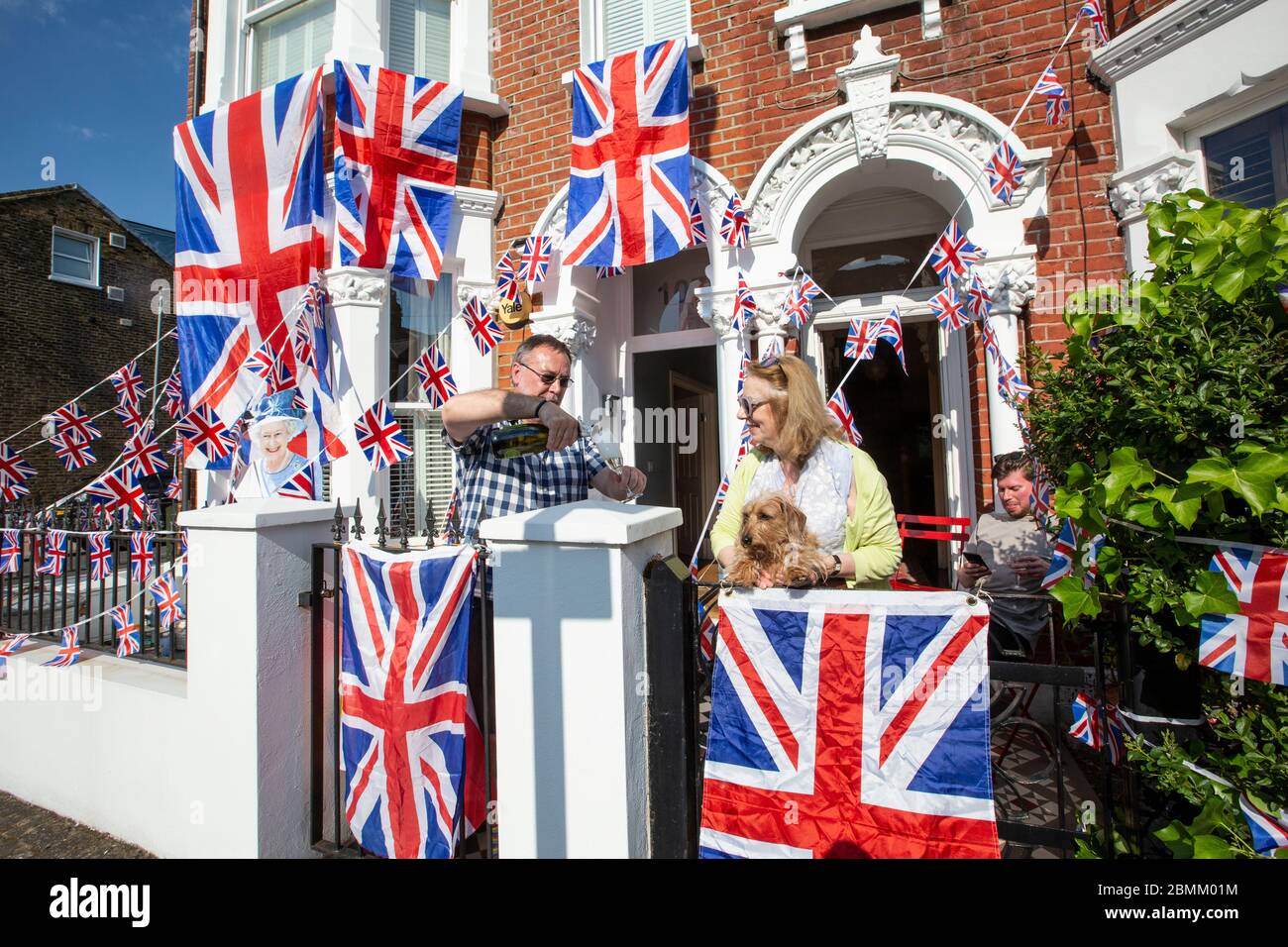People enjoy the Victory in Europe 75th Anniversary day within the restraints of their houses during coronavirus lockdown in Clapham, Southwest London Stock Photo