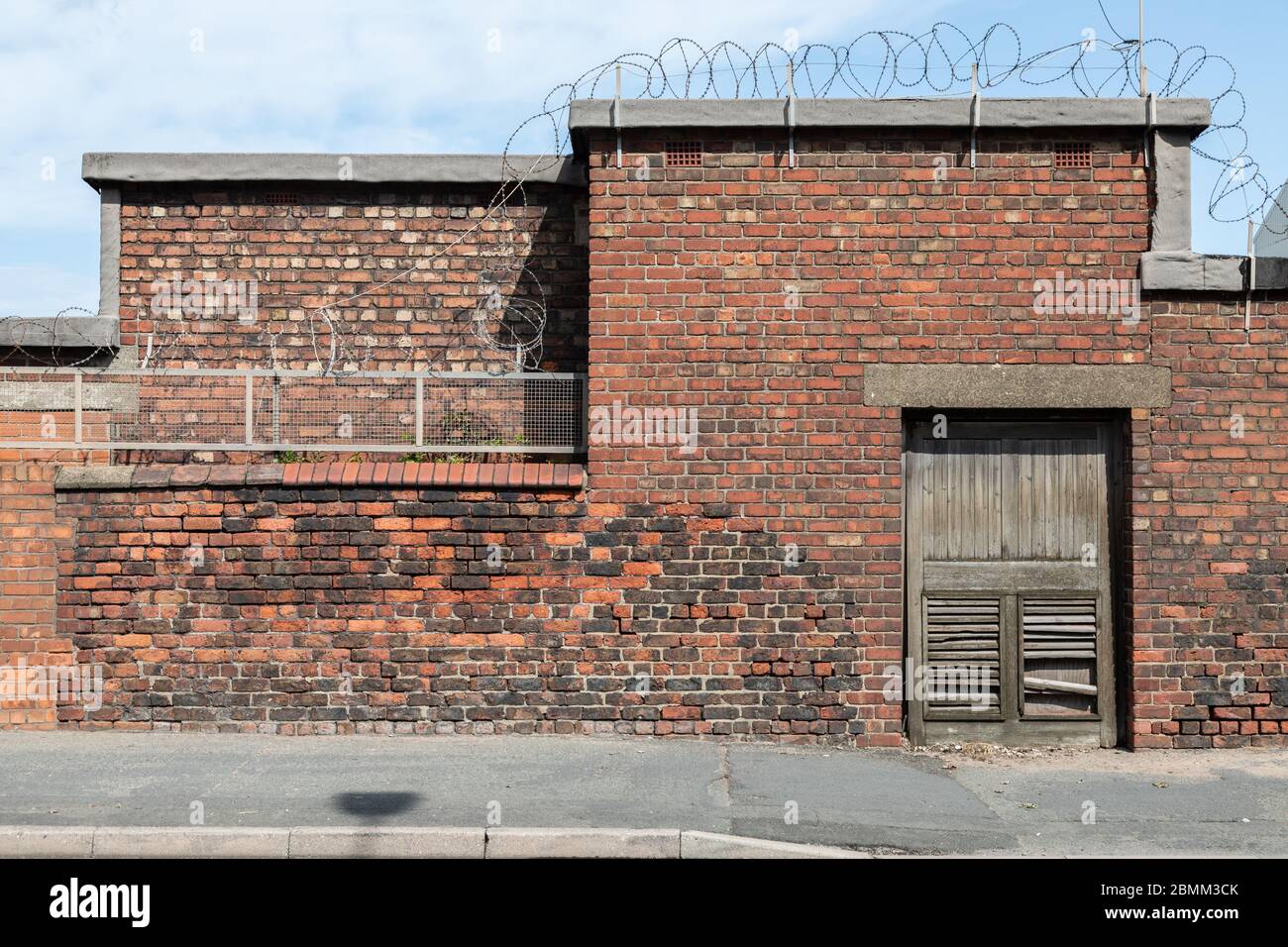 Exterior of brick building with barbed wire in Wallasey Wirral August 2019 Stock Photo