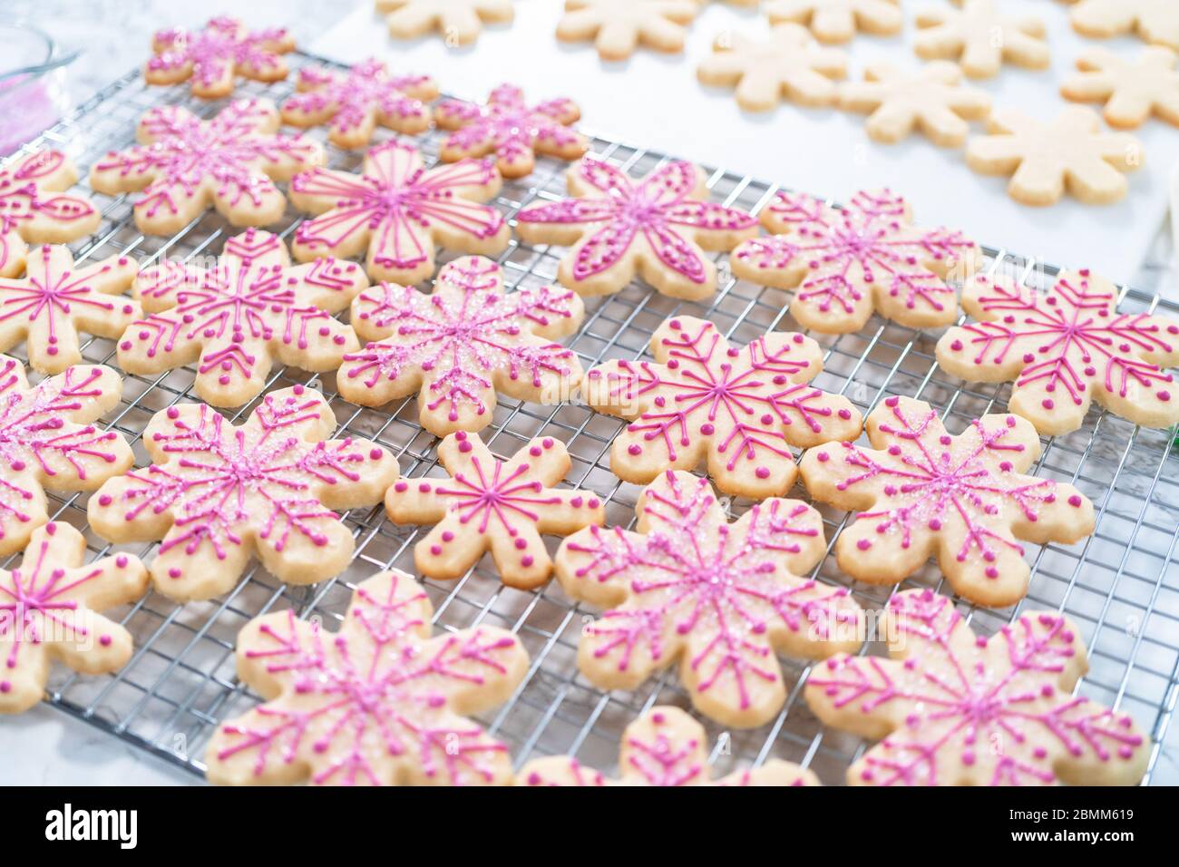 Decorating Christmas sugar cookies with royal icing and sprinkles Stock