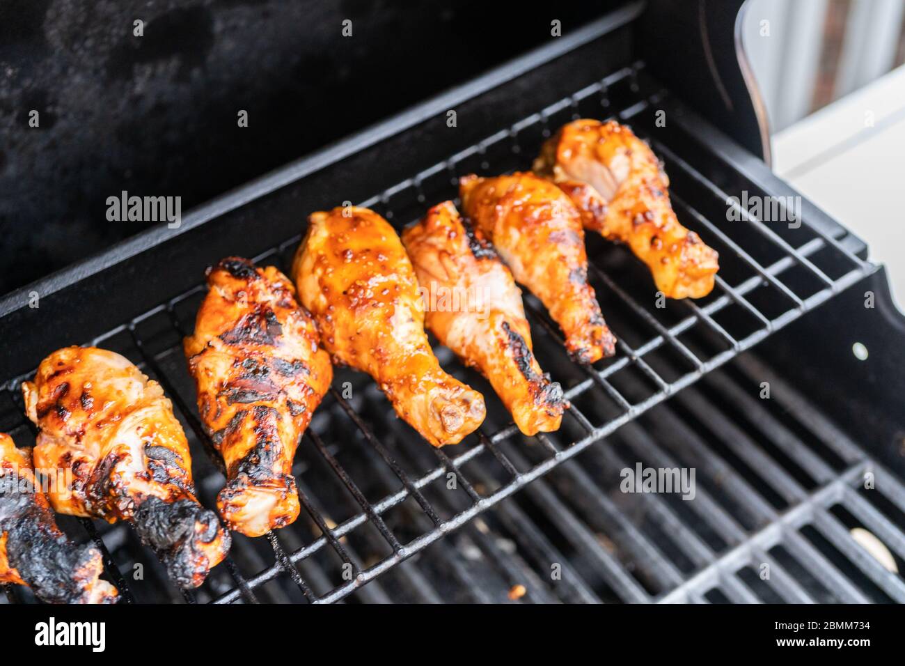 Grilling BBQ chicken drumsticks on outdoor gas grill Stock Photo Alamy