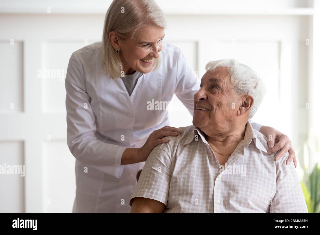 Female nurse take care of elderly male patient Stock Photo