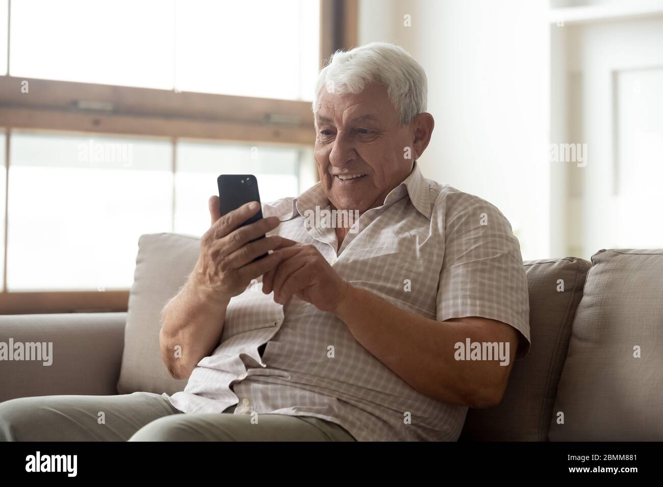 Mature 80s man using modern cell texting Stock Photo