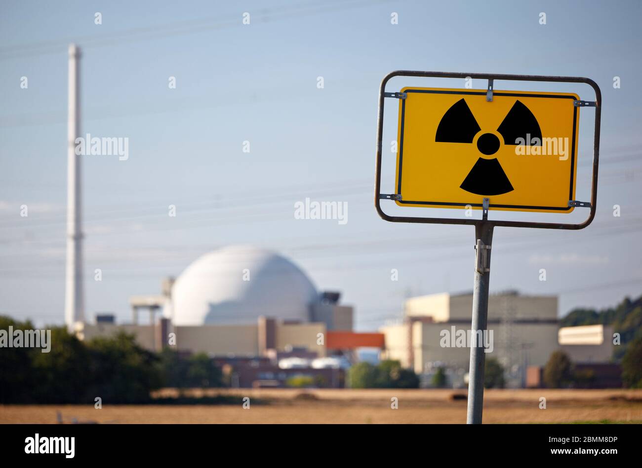 A radioactive warning sign in front of a nuclear power plant. Stock Photo