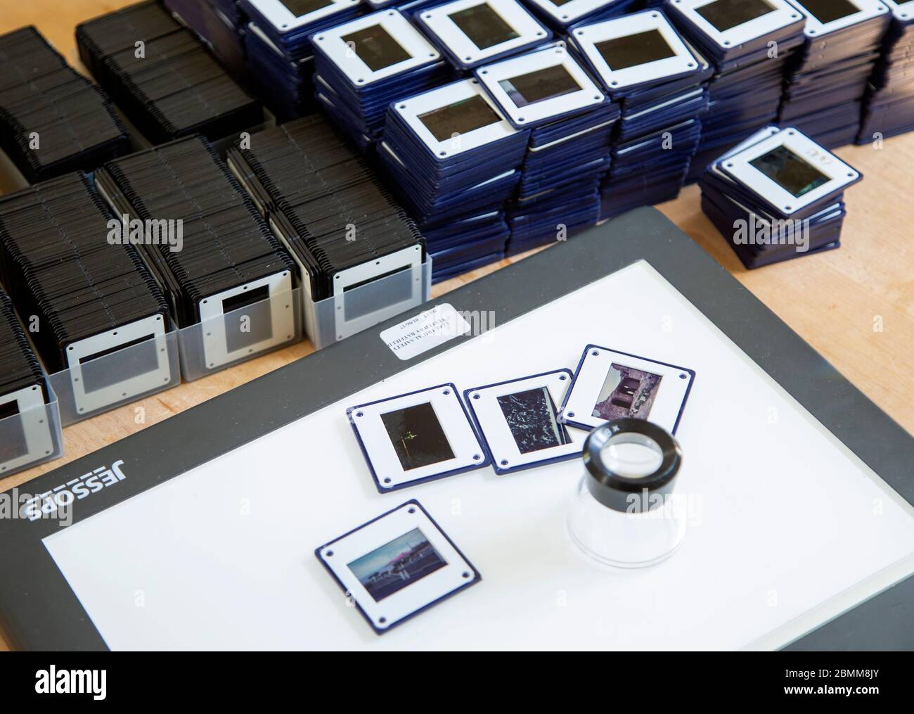 Piles of film transparency slides and Lightbox with viewing enlarger