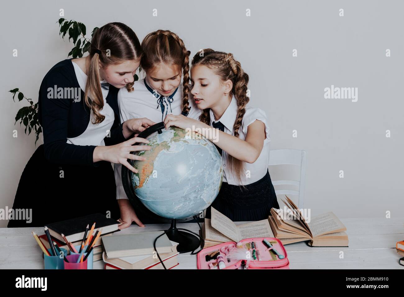 three girls in the school geography lesson learn globe knowledge Stock ...