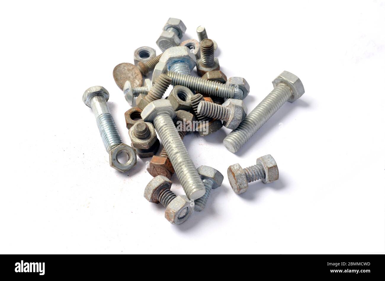 Pile of loose nuts & bolts on white. Stock Photo