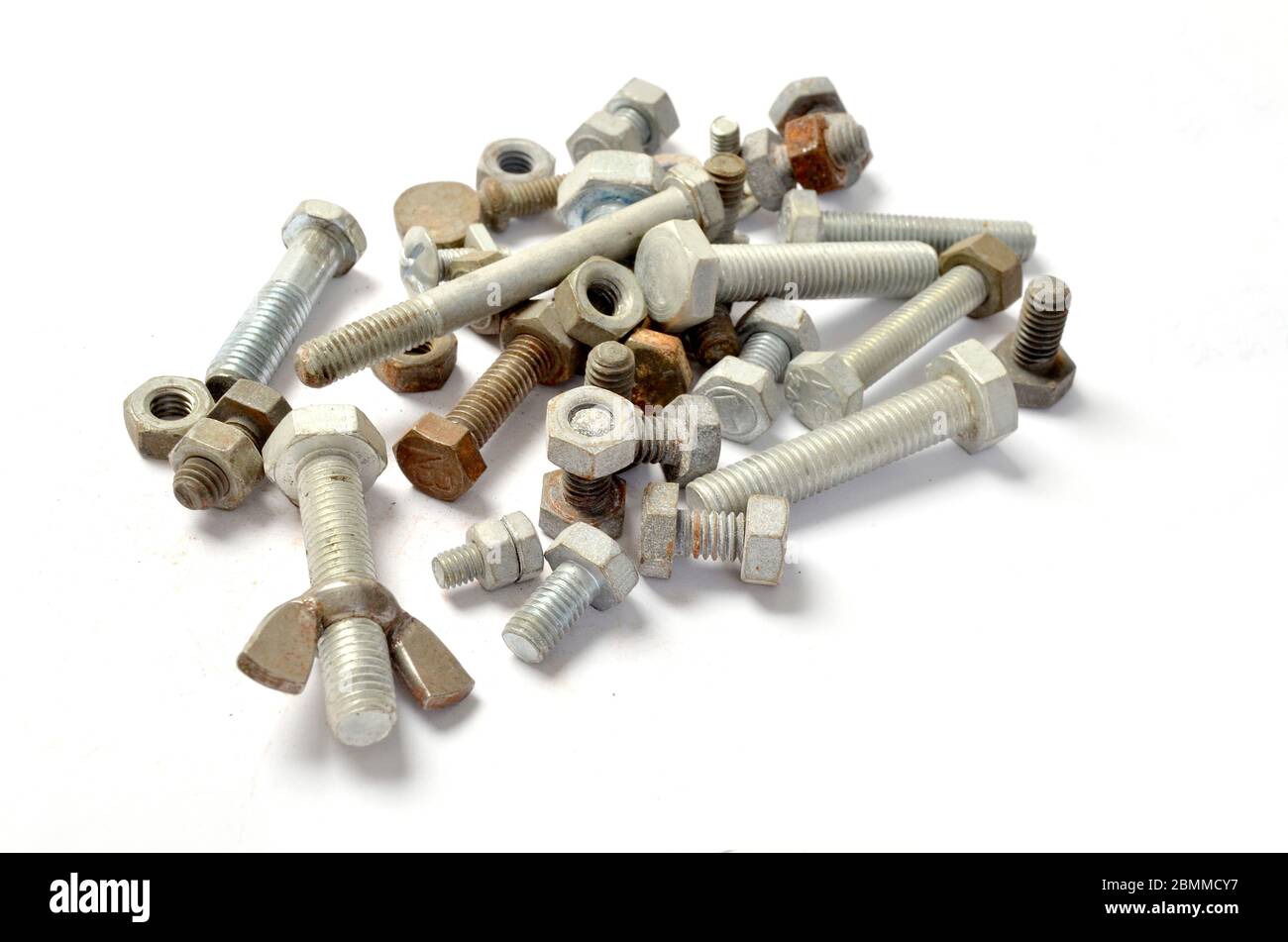 Pile of loose nuts & bolts on white. Stock Photo