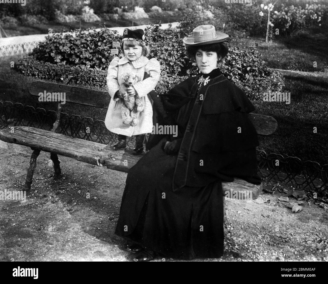Belle epoque : portrait d'une elegante jeune femme, vetue d'un manteau a  cape et d'un chapeau, et sa petite fille, tenant son ours en peluche, dans  un Stock Photo - Alamy