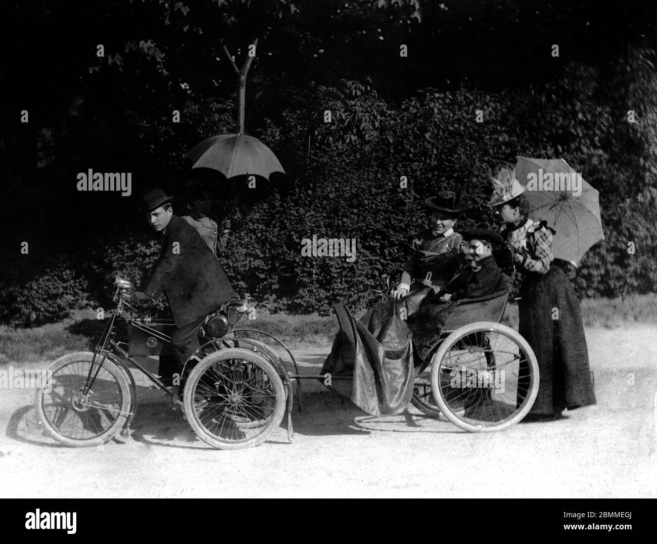 Belle epoque : portrait d'une famille de la bourgeoisie de Royan (Charente-Maritime) en promenade posant sur un moyen de locomotion compose d'un tricy Stock Photo