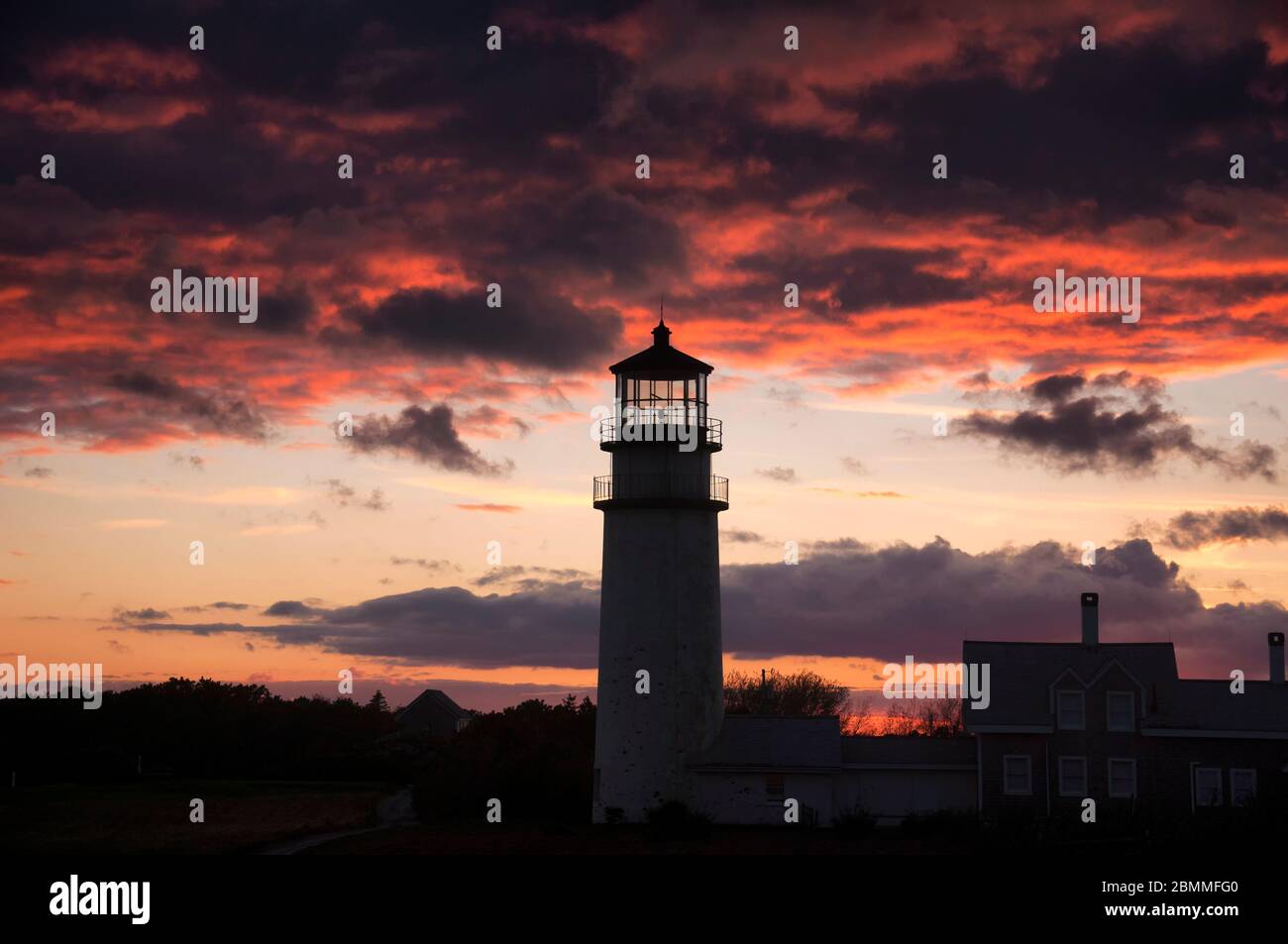 The highland lighthouse in north truro massachusetts on cape cod against a dramatic sunset sky built in 1857. Stock Photo