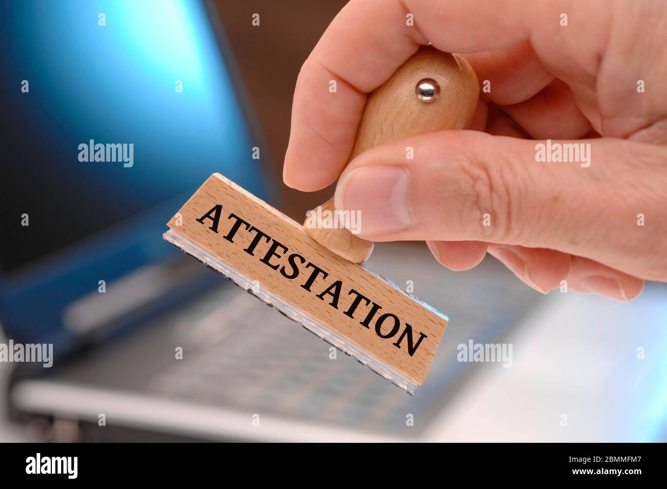attestation  printed on rubber stamp in hand Stock Photo