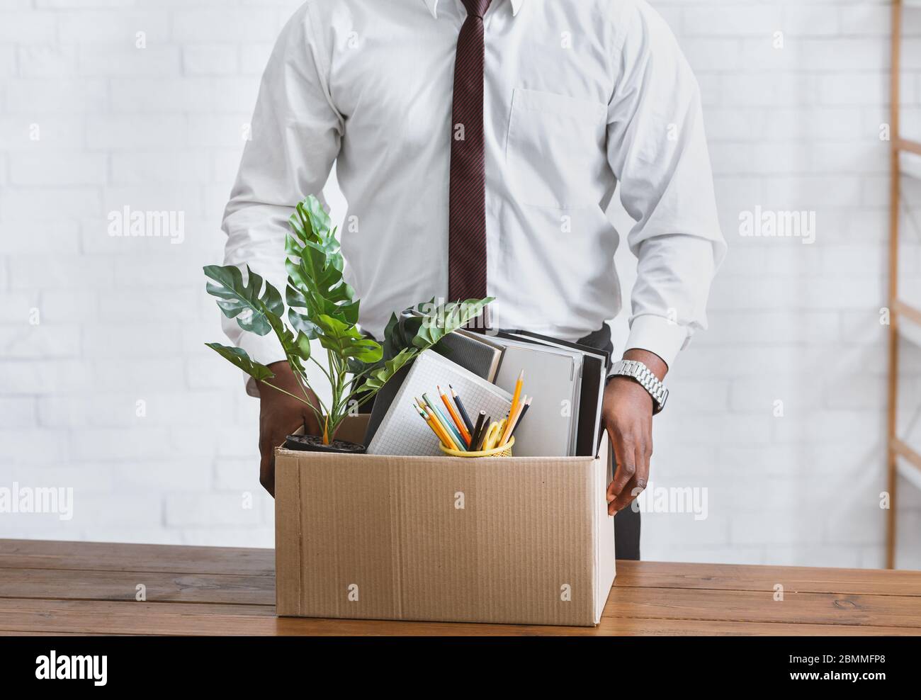 Quitting job concept. Unrecognizable African American employee with box of his belongings at office, closeup Stock Photo