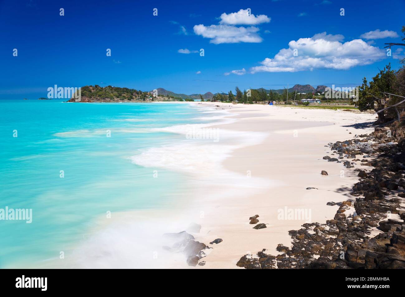 Beautiful Ffryes Beach in Antigua with rocks in the foreground and