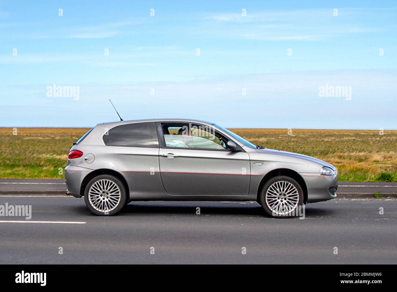 2007 silver Alfa Romeo 147 Collezione T Spark; Vehicular traffic moving vehicles, driving vehicle on UK roads, motors, motoring on the coast road in Southport, UK Stock Photo