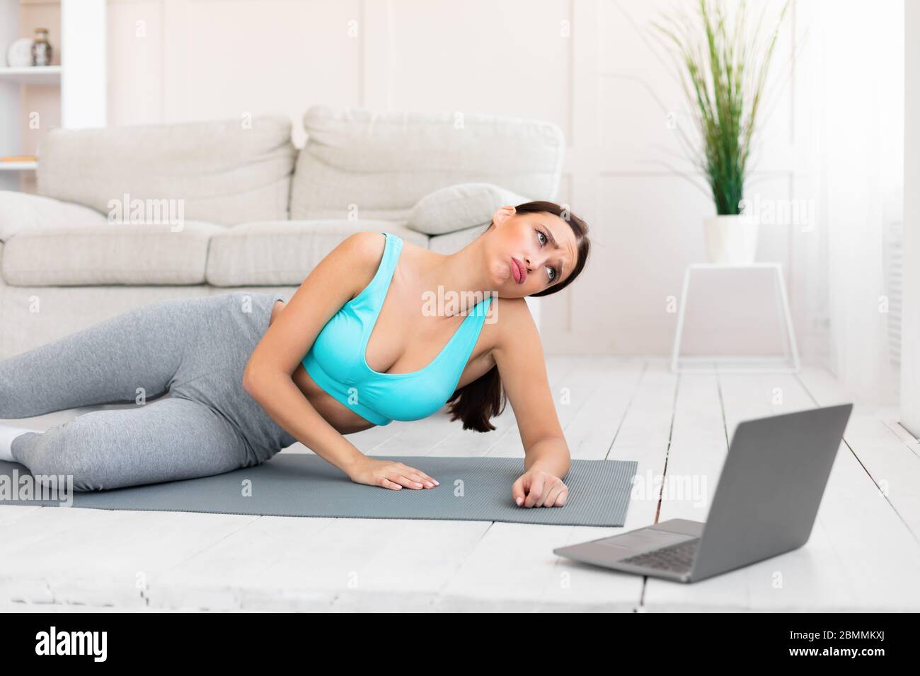 Tired Girl Doing Online Fitness Workout Staying At Home Stock Photo