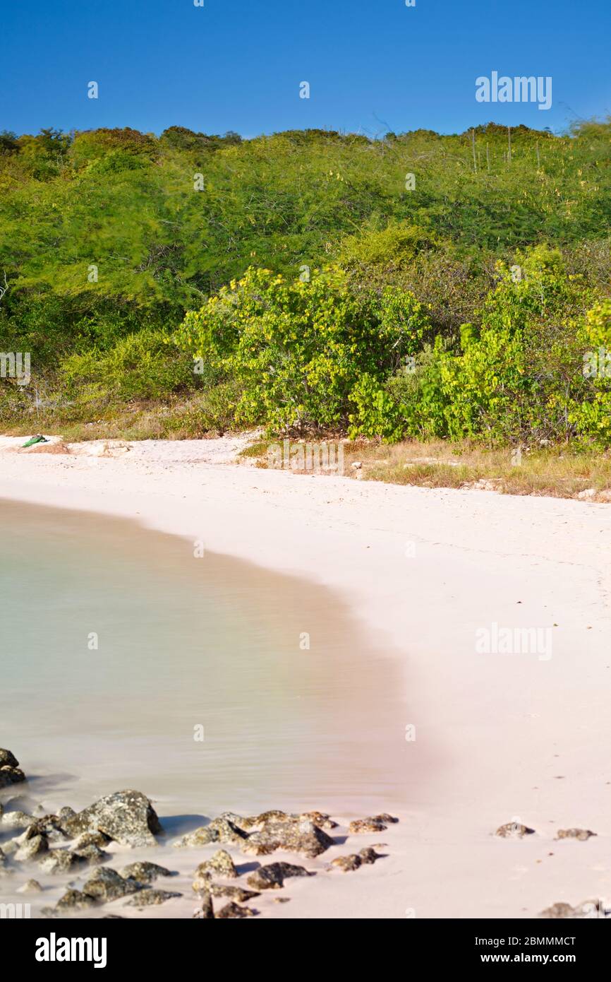 Daytime long exposure of the beautiful Half Moon Bay in Antigua. Stock Photo