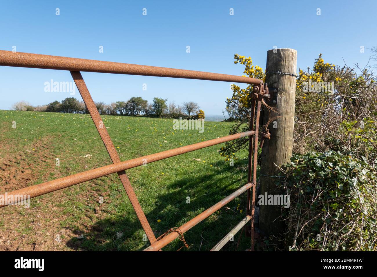 Farm fields viewed through rusty five bar gate Stock Photo - Alamy