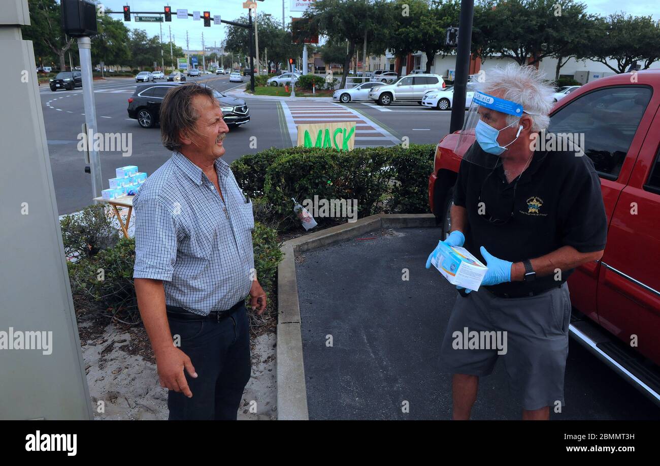 Orlando, United States. 09th May, 2020. Pete Crotty speaks with a prospective customer at a roadside stand where he sells protective face masks during the Coronavirus (COVID-19) crisis.Crotty sold sunscreen to hotels and resorts in the Orlando area until they were forced to close due to the pandemic. Credit: SOPA Images Limited/Alamy Live News Stock Photo
